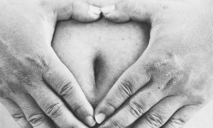 fat man make a heart shape sign on big belly.